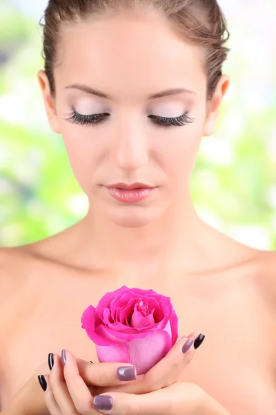 Schönes Mädchen mit Rose auf natürlichem Hintergrund — Stockfoto