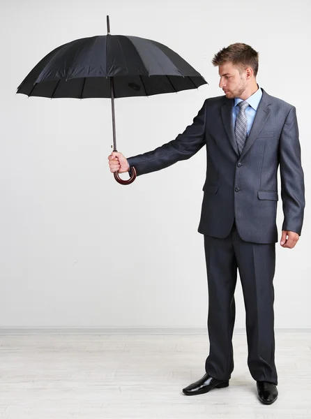 Businessman with umbrella. on gray background Royalty Free Stock Photos