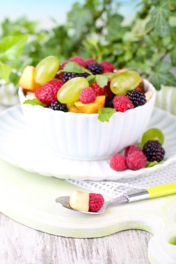 parlak zemin üzerine ahşap masa üzerinde kase meyve salatası