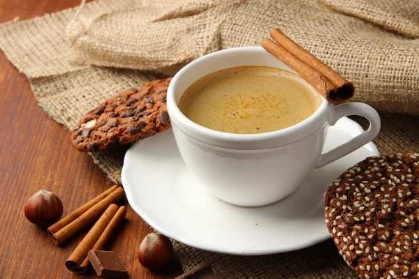 Xícara de café saboroso com biscoitos saborosos, em fundo de madeira — Fotografia de Stock