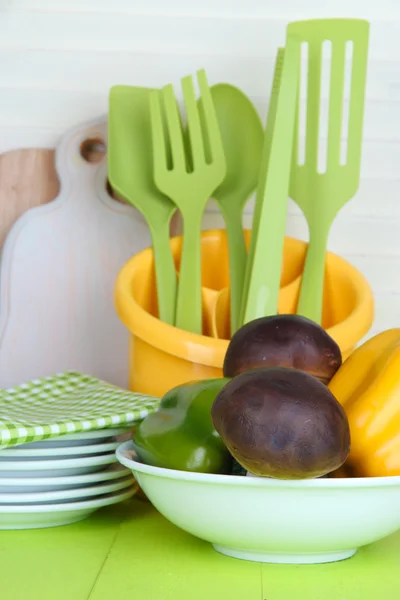 Utensilios de cocina de plástico en taza sobre mesa de madera —  Fotos de Stock