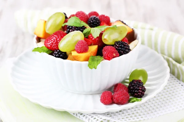 Ensalada de frutas en tazón, sobre fondo de madera —  Fotos de Stock