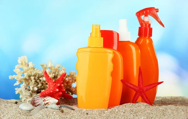 Bottles with suntan cream, on blue background — Stock Photo, Image