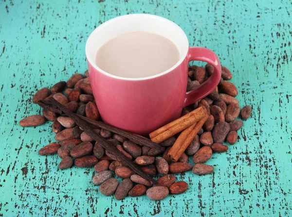 Cocoa drink with spices and cocoa beans on wooden background — Stock Photo, Image