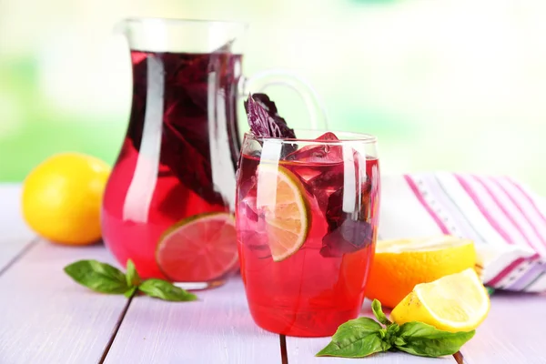 Röd basilika saft i kannan och glas, på ljus bakgrund — Stockfoto