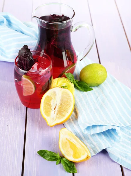 Limonata di basilico rosso in brocca e vetro, su fondo di legno — Foto Stock