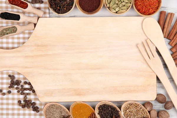 Various spices and herbs with empty wooden board — Stock Photo, Image