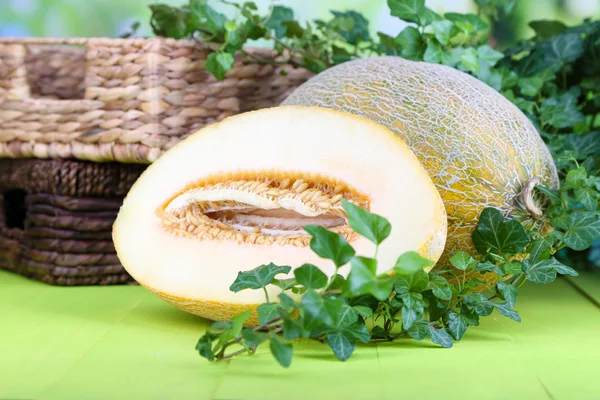 Rijpe meloenen op houten tafel op natuurlijke achtergrond — Stockfoto