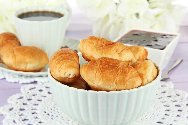 Croissants savoureux et tasse de café sur la table close-up — Photo