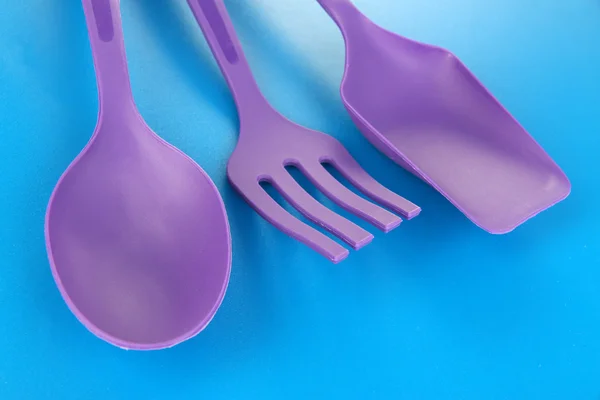 Plastic kitchen utensils on blue background — Stock Photo, Image