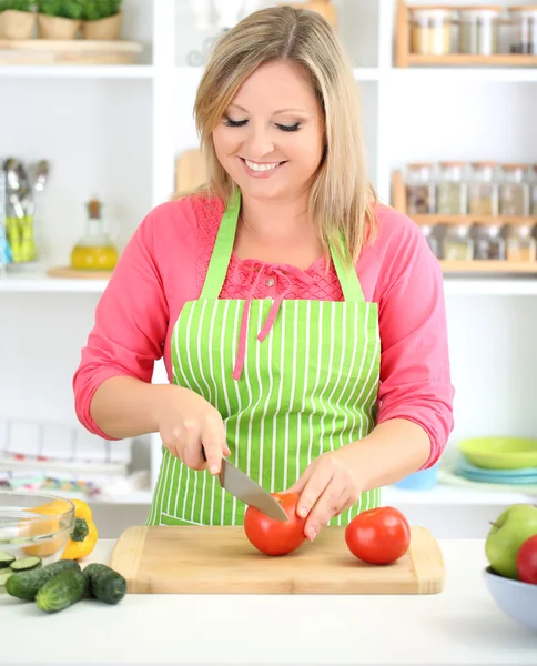 Happy smiling woman in kitchen preparing vegetable salad — Stock Photo, Image