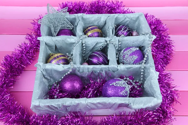 Juguetes de Navidad en caja de madera sobre fondo rosa — Foto de Stock