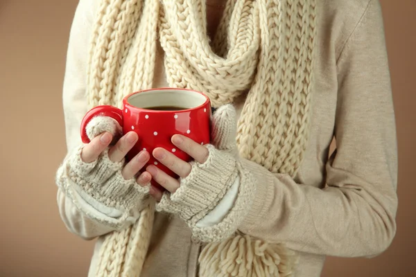 Female hands with hot drink, on color background — Stock Photo, Image