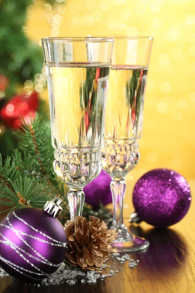 Karácsonyi díszek és két pezsgő szemüveg, a világos háttér összetétele — Stock Fotó