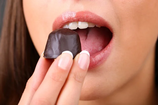 Closeup of woman eating chocolate candy Stock Picture