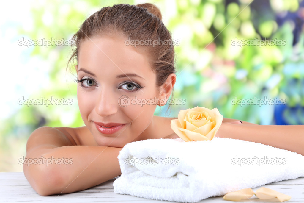 Beautiful girl with spa accessories on natural background
