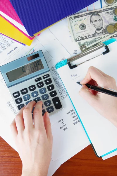 Mujer manos contando con calculadora en fondo de mesa de trabajo —  Fotos de Stock