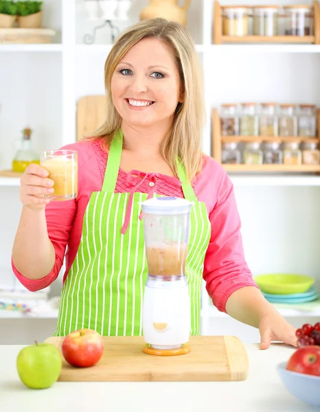 Feliz mujer sonriente en la cocina preparando cóctel de frutas frescas —  Fotos de Stock