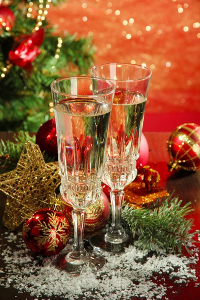 Yılbaşı süsleri ve parlak zemin üzerine iki şampanya bardağı kompozisyonu — Stok fotoğraf
