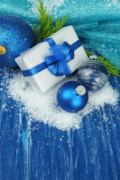Compoziție cu bile de Crăciun, cutie cadou și zăpadă pe fundal de lemn color — Fotografie, imagine de stoc