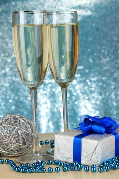 Bicchieri di champagne con scatola regalo su sfondo lucido — Foto Stock