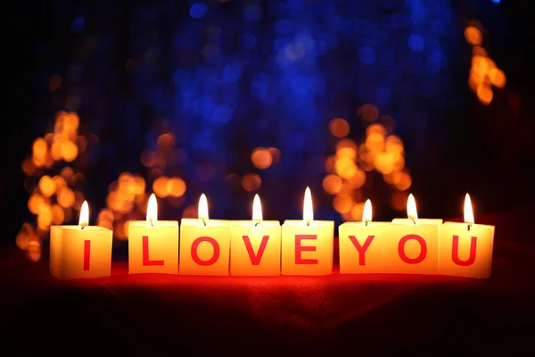 Candles with printed sign I LOVE YOU,on blur lights background — Stock Photo, Image