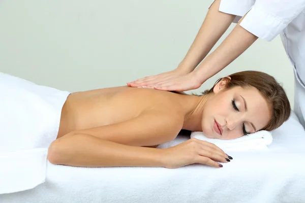 Beautiful young woman on massage table in cosmetic salon close up — Stock Photo, Image