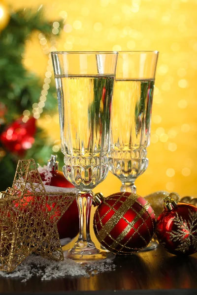 Koostumus joulukoristeilla ja kahdella samppanjalasilla, kirkkaalla taustalla — kuvapankkivalokuva