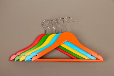 gri arka plan üzerinde renkli elbise askıları