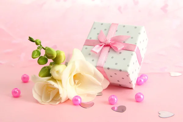Schöne romantische Geschenkschachtel und Blume auf rosa Hintergrund — Stockfoto