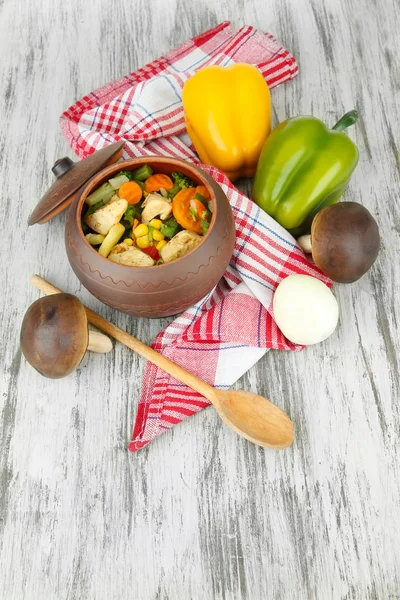 Baked mixed vegetable with chicken breast in pot, on wooden background — Stock Photo, Image
