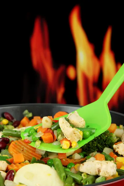 Casserole avec légumes et viande sur poêle, sur fond de feu — Photo