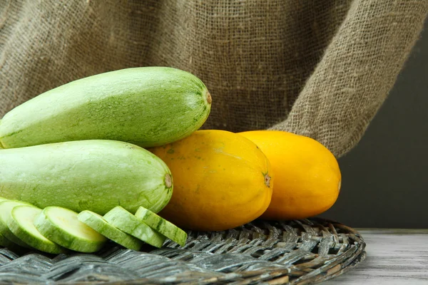 Sliced and whole raw zucchini on burlap background — Stock Photo, Image