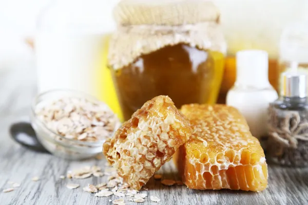 Miele e latte spa con oli e miele sulla tavola di legno primo piano — Foto Stock