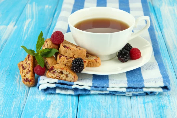 Taza de té con galletas y bayas en primer plano de la mesa —  Fotos de Stock