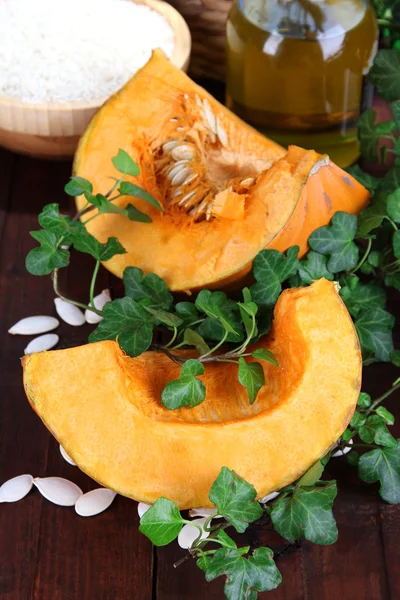 Cut pumpkin with ingredients for cooking on wooden table close-up — Stock Photo, Image