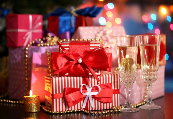 Birçok hediyeler ve bardak şampanya parlak zemin üzerine — Stok fotoğraf