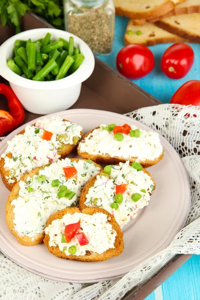 Sanduíches com queijo cottage e verdes na chapa na mesa de madeira close-up — Fotografia de Stock