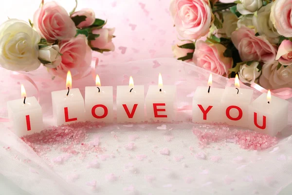 Candles with printed sign I LOVE YOU, on light background — стоковое фото