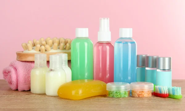 Hotel amenities kit on table on pink background — Stock Photo, Image