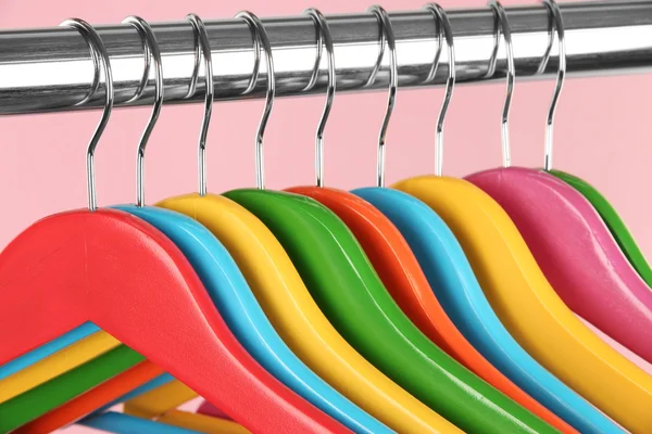 Colorful clothes hangers on pink background — Stock Photo, Image