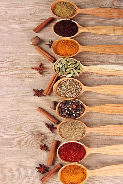 Assortimento di spezie in cucchiai di legno su fondo di legno — Foto Stock