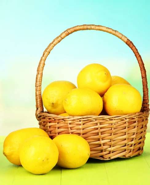 Parlak zemin üzerinde tablo hasır sepet içinde olgunlaşmış limon — Stok fotoğraf