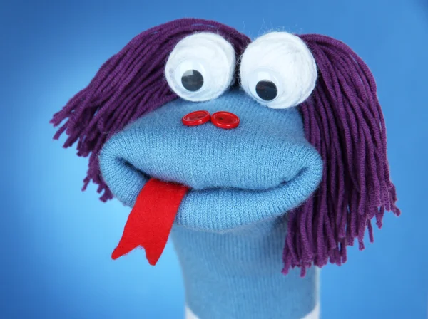 Cute sock puppet on blue background — Stock Photo, Image