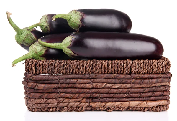 Verse aubergines in rieten mand geïsoleerd op wit — Stockfoto