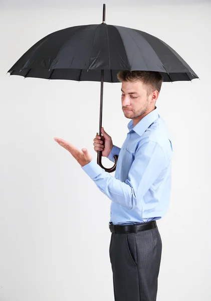 Geschäftsmann mit Regenschirm. auf grauem Hintergrund — Stockfoto