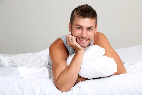 Красивый молодой человек в постели — стоковое фото