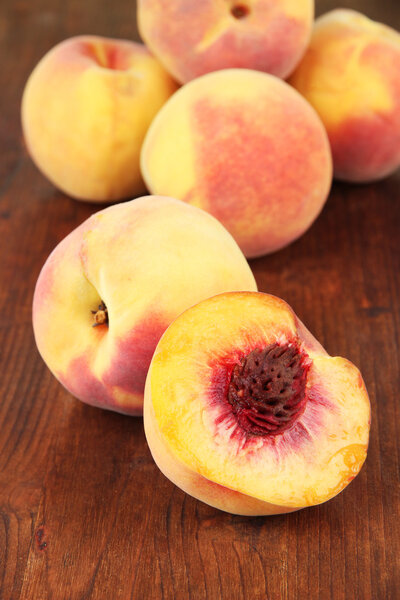 Ripe sweet peaches, on wooden background