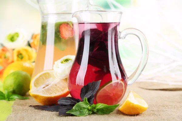 Red basil lemonade in jug and glass, on wooden table, on bright background — Stock Photo, Image