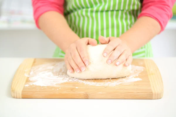 Руки женщины в муке крупным планом смешивают тесто на столе — стоковое фото